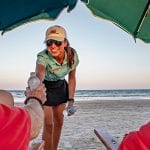 Palmilla Beach Resort's VIP Beach Services Woman Handing A Bottle Of Water To Beach Tourist