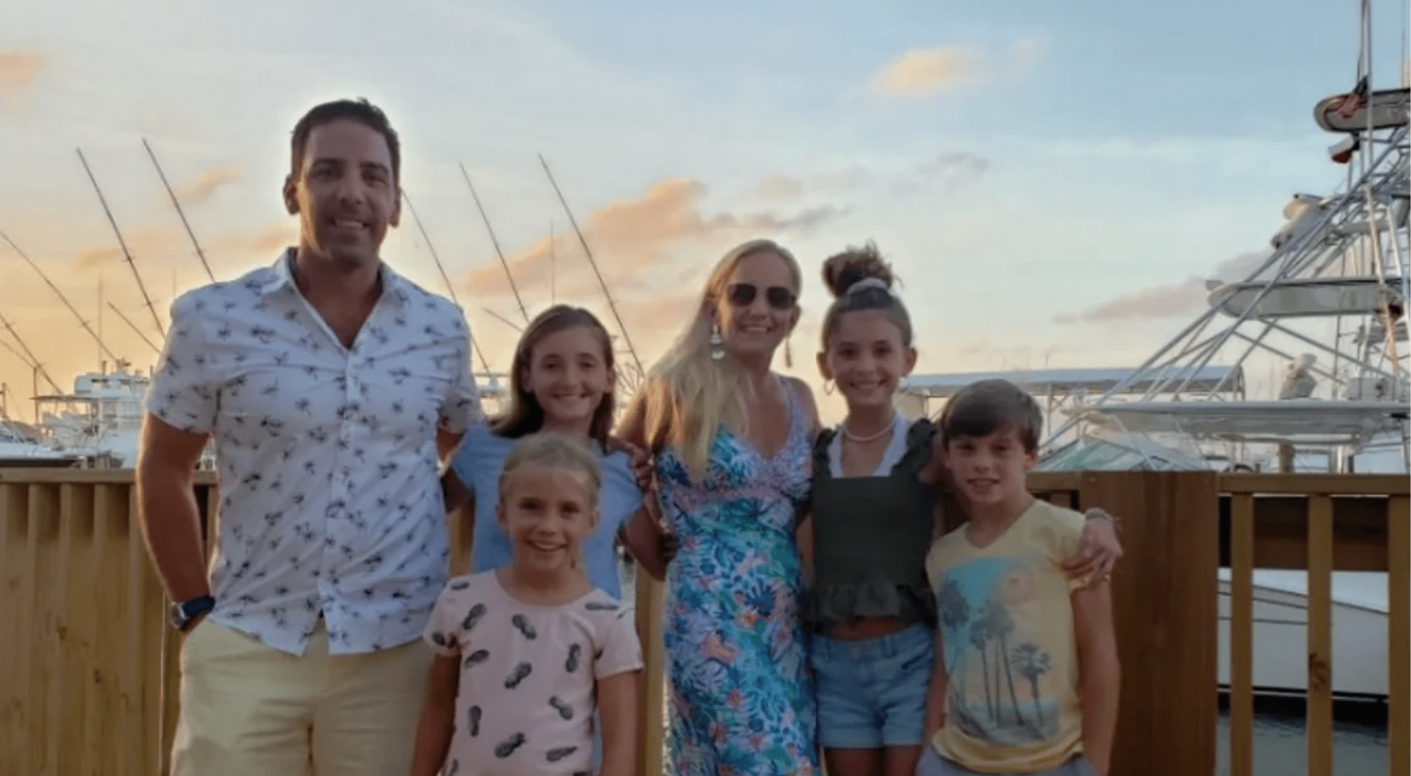 We Love Palmilla Beach Resort - Meet The Cronins Article featured image showing the family of six at a harbor with a yacht in the background