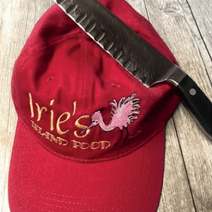 Island Food Article Featuring Iries Restaurant Red Hat With Sharpened Chef Knife Sitting Atop It