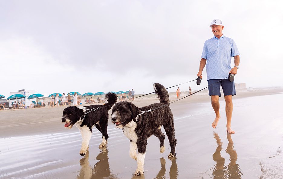 Man Walking his Dogs on Beach at Palmilla Beach
